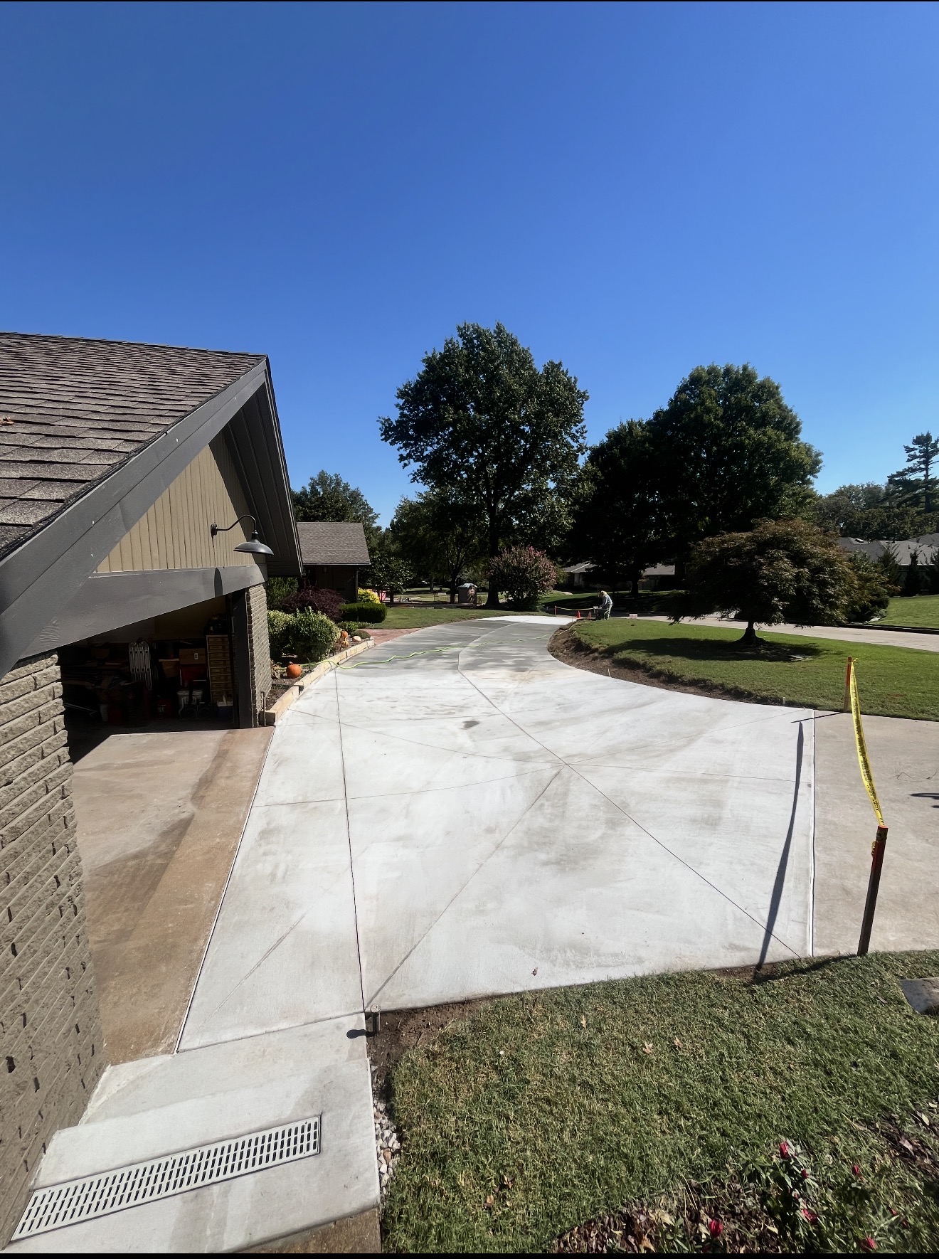 Wide concrete driveway with control joints and trench drain for drainage control